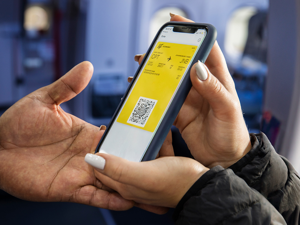 Hand holding a smartphone displaying a LIFT mobile boarding pass.