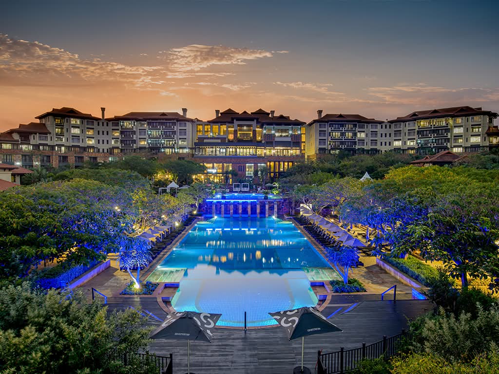 The Capital Hotel and Apartments illuminated at night with pool view, Sandton Johannesburg